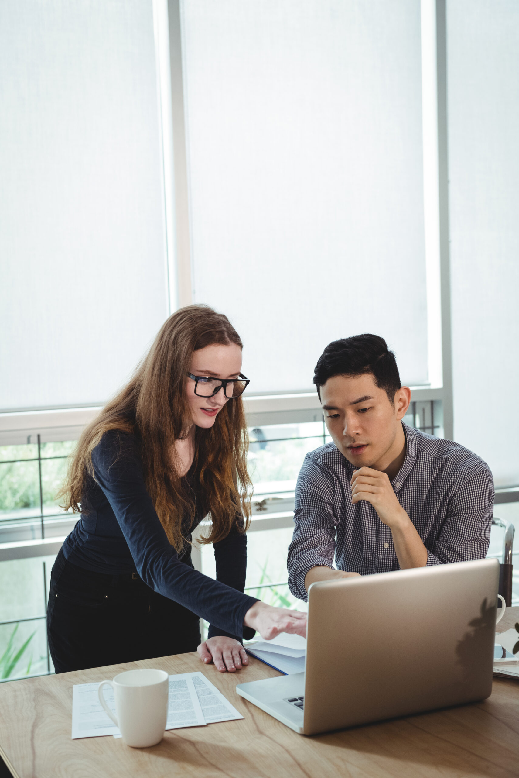 Business executives discussing over laptop in office
