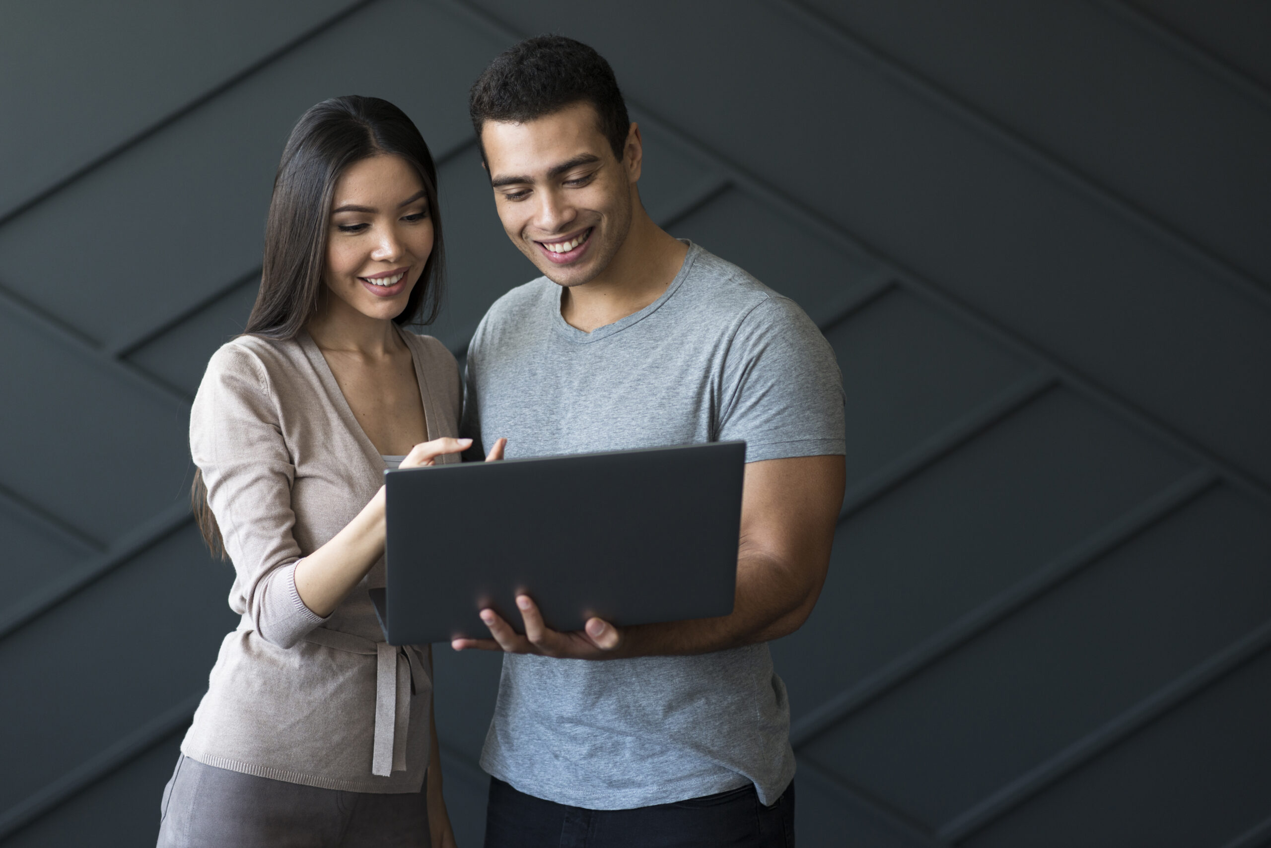 vista-frontal-masculino-adulto-y-mujer-sosteniendo-una-computadora-portatil