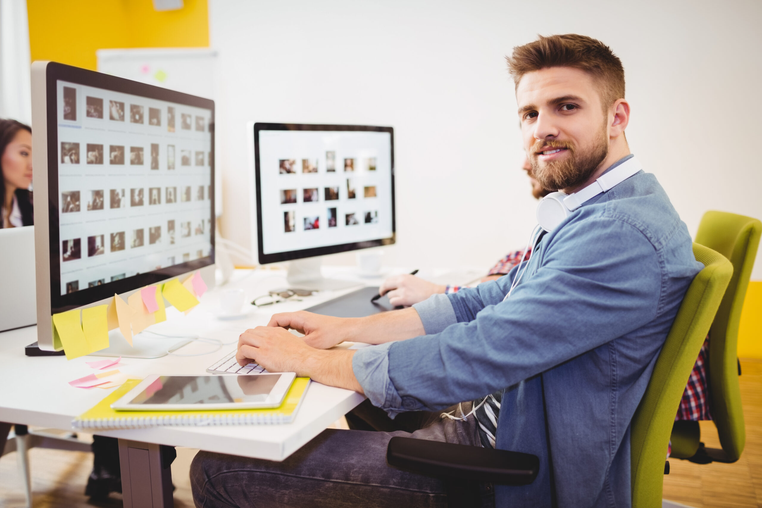 Portrait of confident young male editor working in creative office