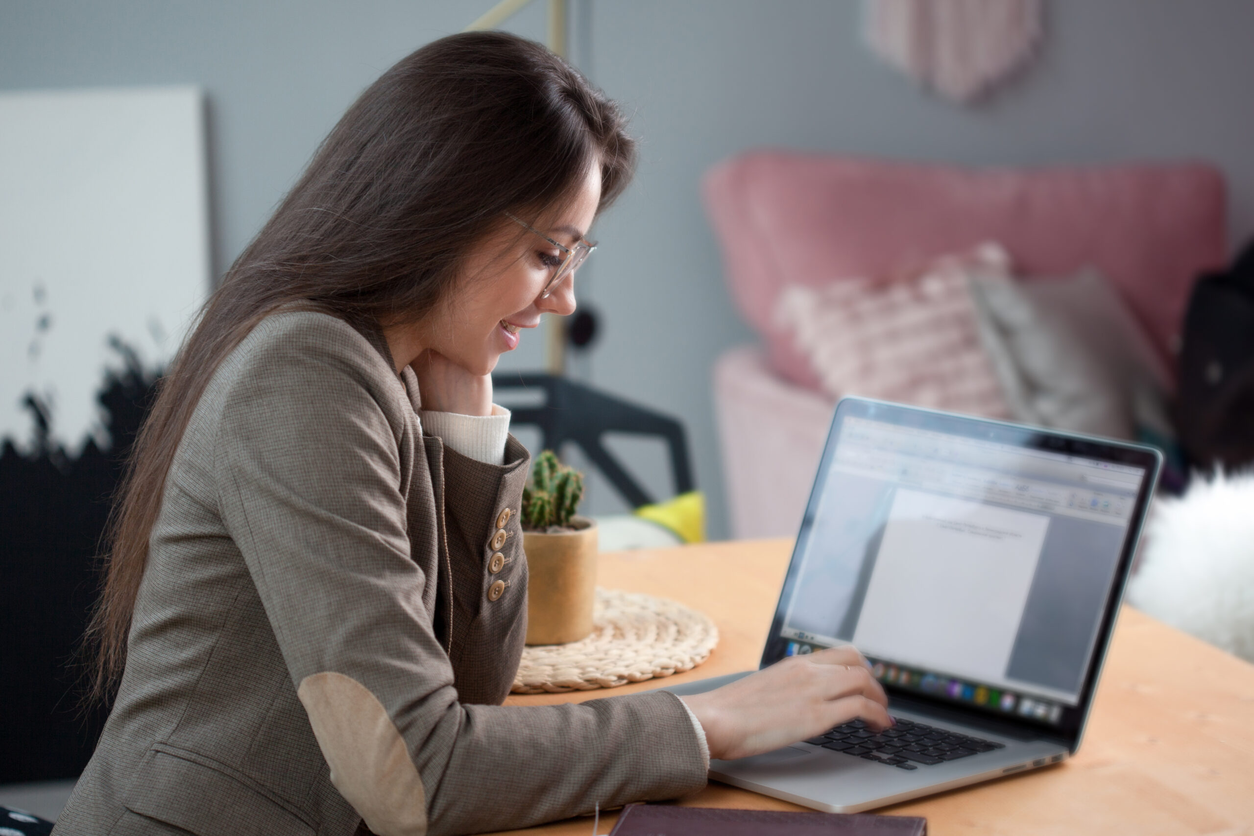 Business woman in a stylish modern office. Stylish young woman sitting at table and working with laptop, casual style