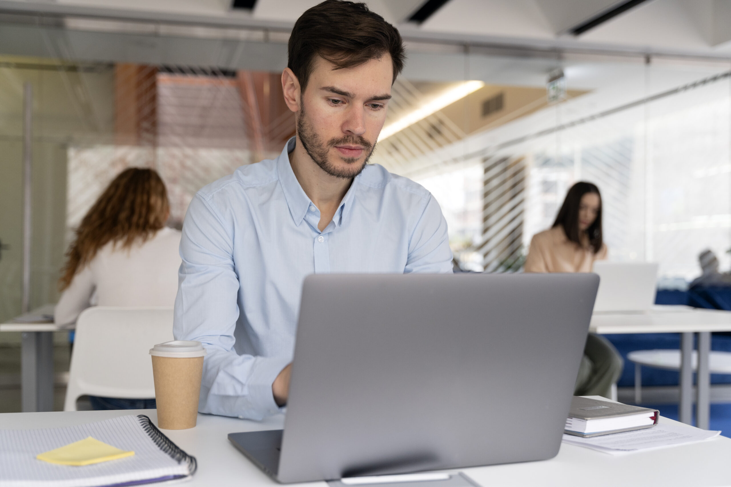 hombre-de-negocios-joven-que-trabaja-en-su-escritorio-con-ordenador-portatil